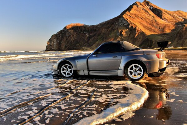 Silver car on the surf line