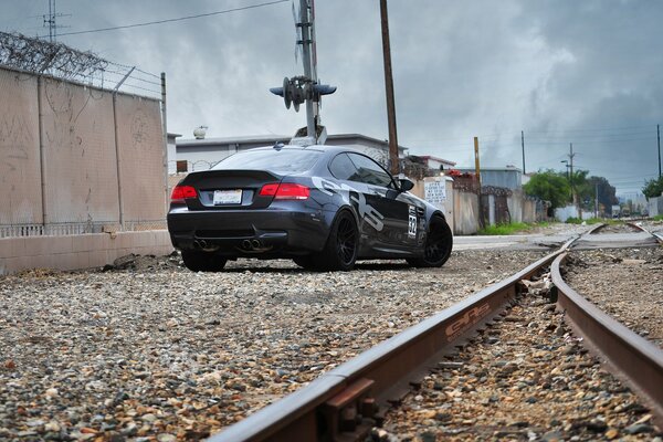 A black car with inscriptions is standing near the rail