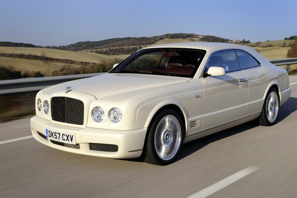 Snow-white Bentley on the road in the desert