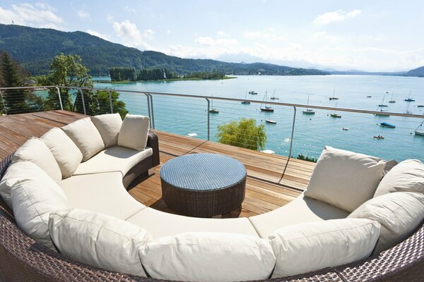 Semicircular cozy sofa on the terrace overlooking the lake