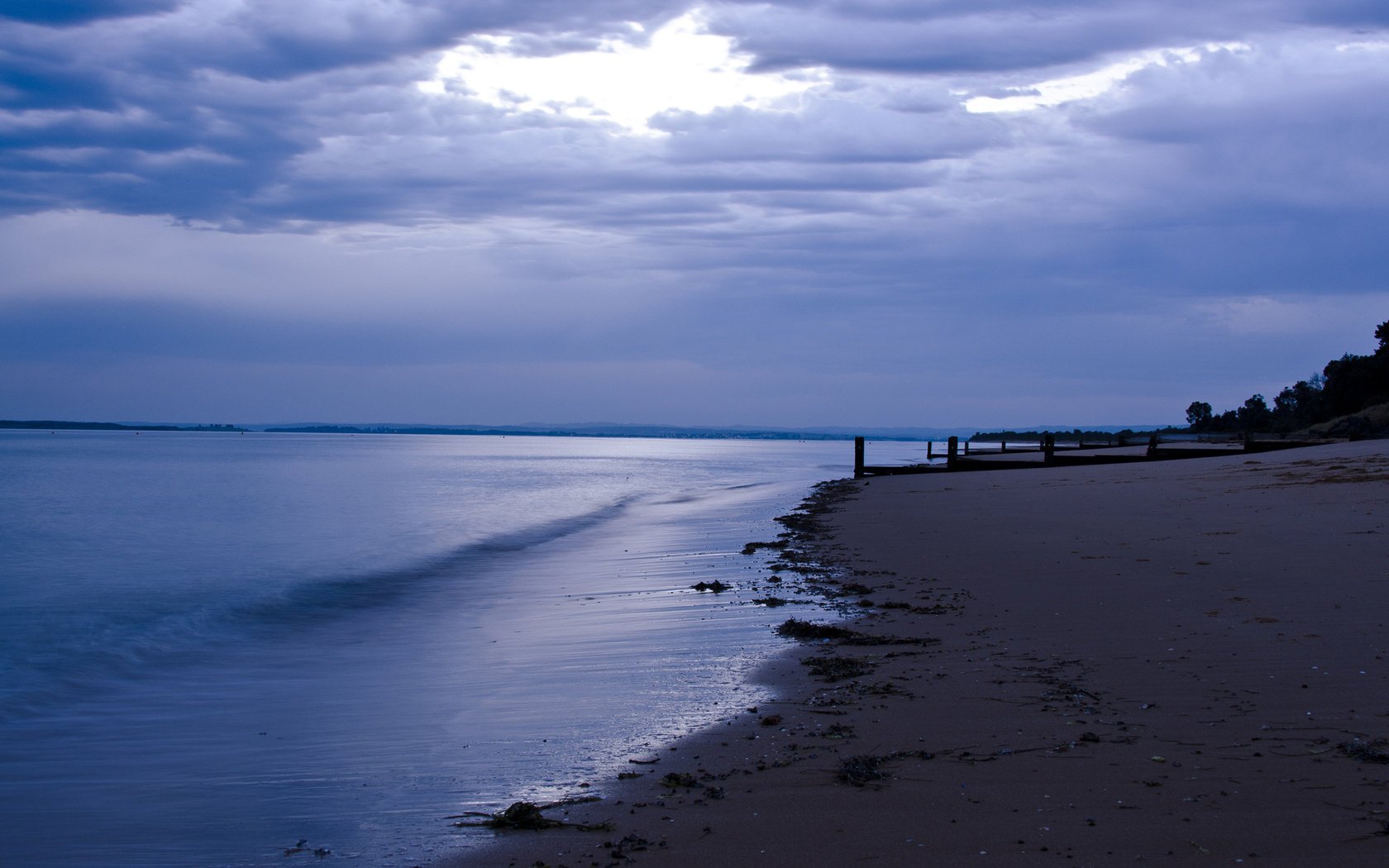 pilares crepúsculo mar arena nubes