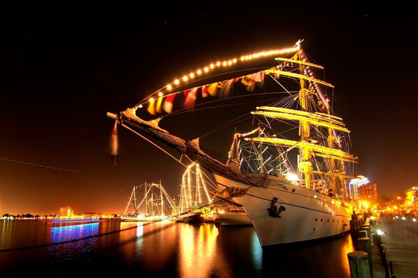 Elegante barco atraca en el fondo de la ciudad de la noche