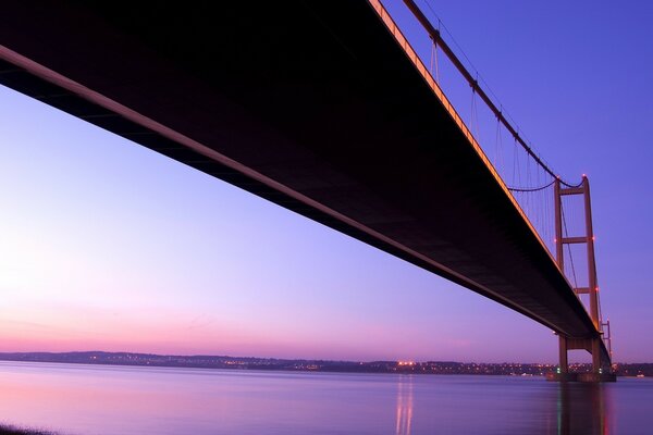 La puesta de sol púrpura es visible a través del puente