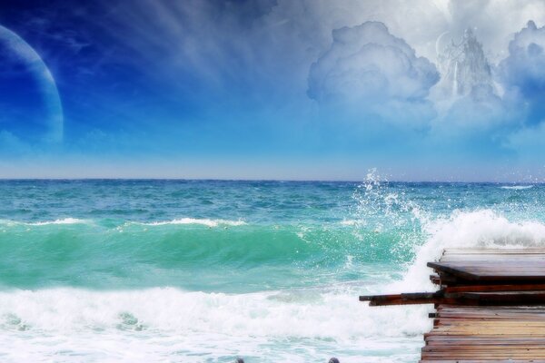 Les vagues de la mer verte se brisent sur le quai sous le ciel bleu, dans lequel le château d air des nuages est visible