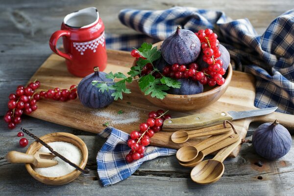 Red currant on a board with sugar and figs