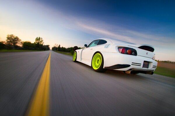 Honda blanco con Llantas verdes corriendo por la pista