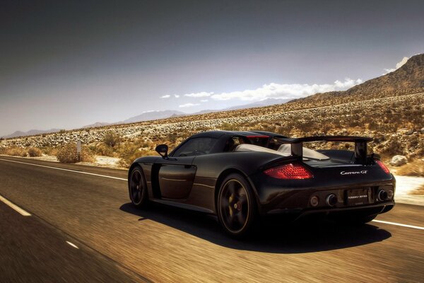 Porsche carrera noir sur la route dans les prairies