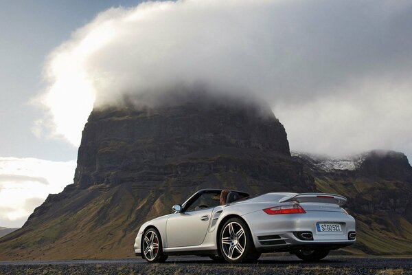 Convertible on the background of nature with mountains and clouds