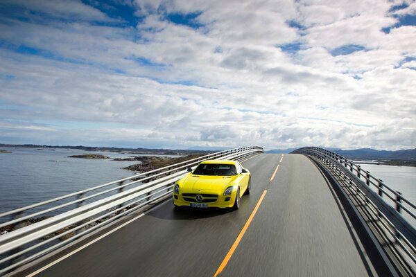 Un puente con nubes. Mercedes amarillo