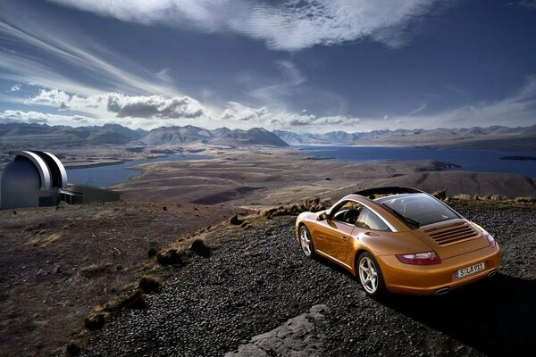 Auto en tierra cerca del río, en el cielo nubes