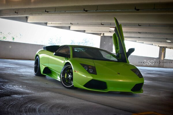 Lamborghini verde con puerta abierta verticalmente