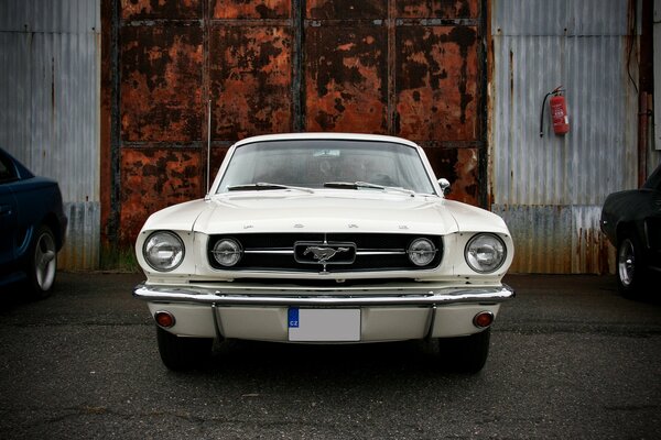 Viejo ford mustang en el fondo de la puerta vieja