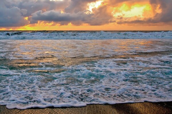 Clouds over waves at sea surf