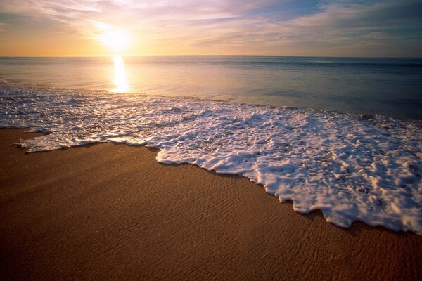 Leichte schaumige Wellen am Meer