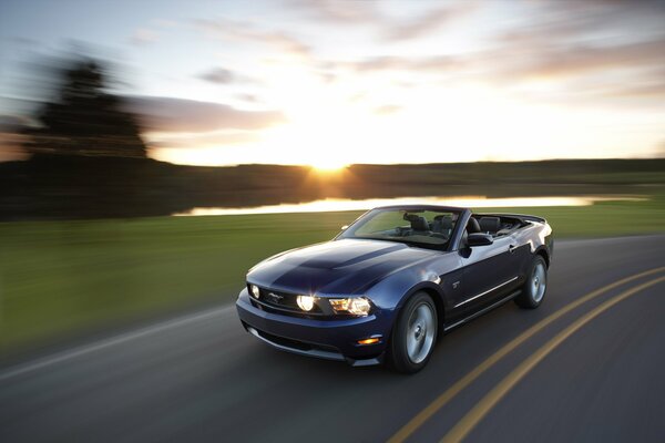 The mustang gt convertible is driving on the road at high speed