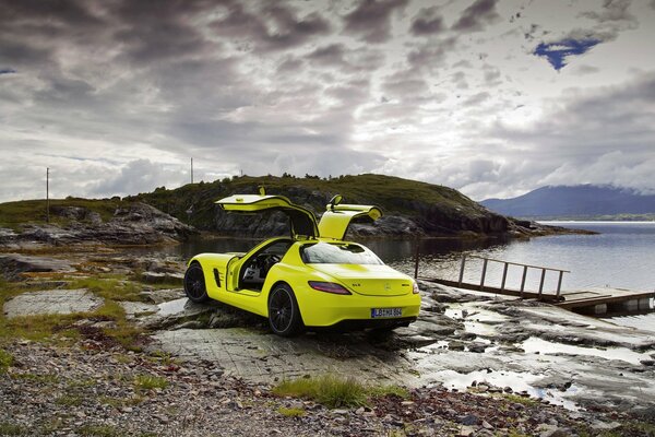 Yellow car on the seashore with the doors raised up