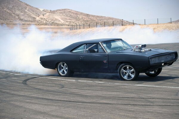 Dodge Charger in a skid with a cloud of exhaust gases