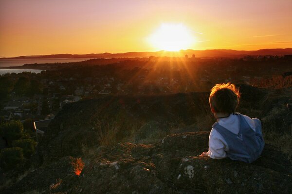 Bambino al mattino sullo sfondo del tramonto rosso