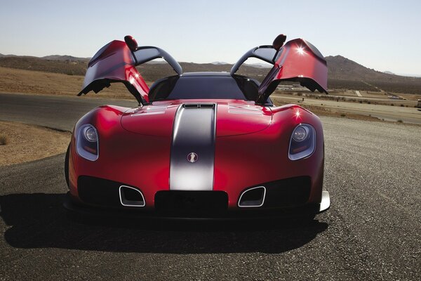 Red sports car on the road doors up