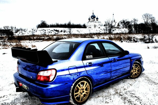 Subaru bleu se dresse sur le fond de la cathédrale