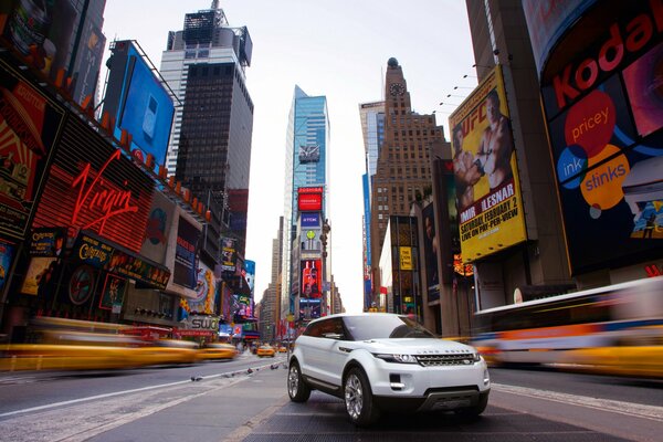 Rover en la carretera en la metrópoli entre anuncios y rascacielos