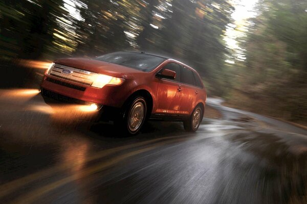 Ford corre a gran velocidad en una carretera mojada