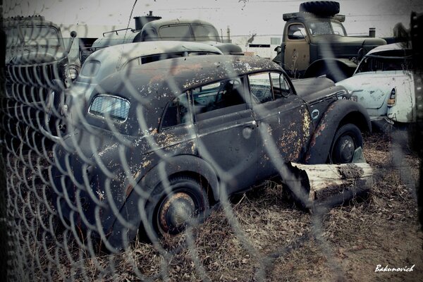 RETRO CARS IN THE PARKING LOT AWAITING RESTORATION