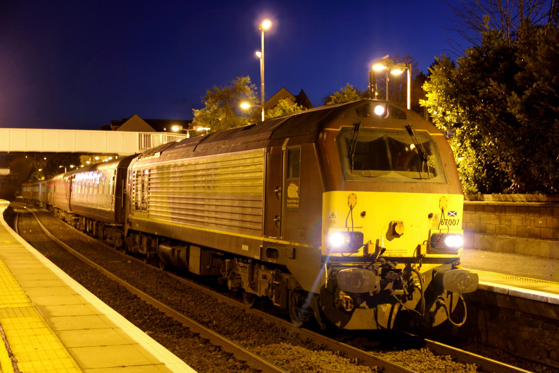 railway station evening lights passenger train locomotive wagons platform track rail