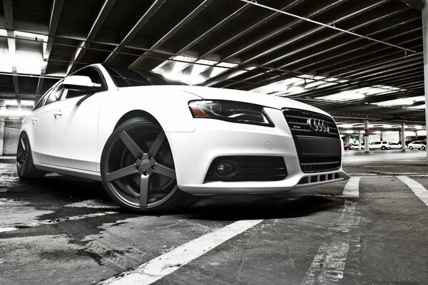 Audi blanche dans un parking souterrain