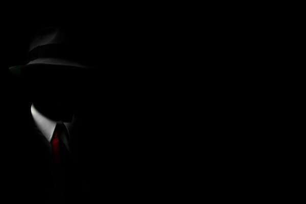 Invisible silhouette of a man in a hat with a red tie