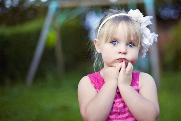 A thoughtful-looking girl in a pink dress