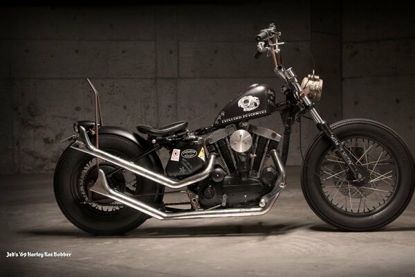 Black Harley-davidson in semi-darkness against the background of concrete walls