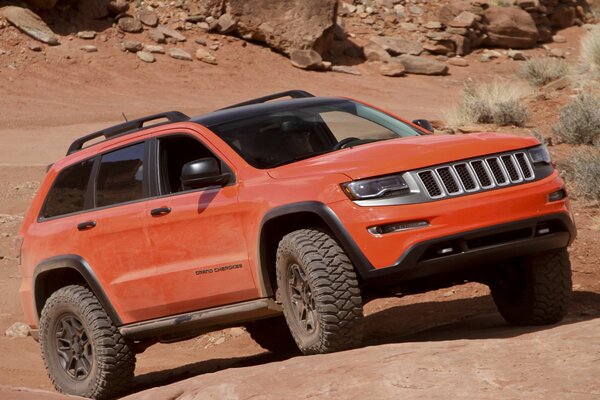 SUV rouge sur des pierres de sable