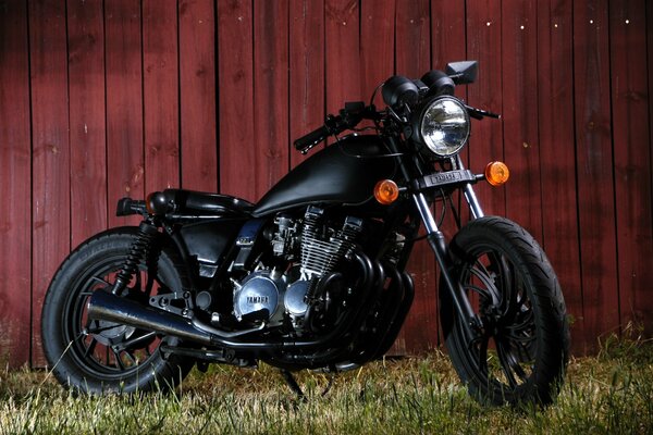 Motorcycle xj 650 on the grass on the background of a wooden fence