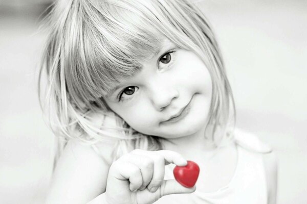 The girl shyly shows a heart