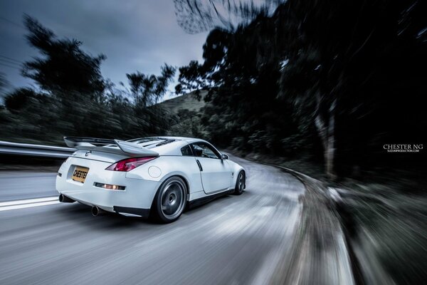 White car driving at speed on the road