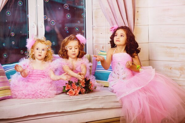 Chicas en rosa soplando burbujas