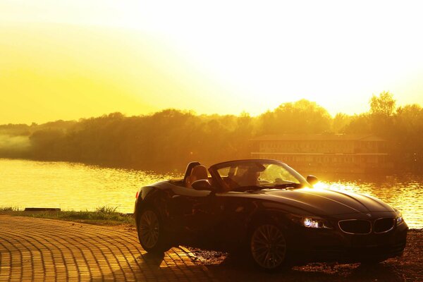 Das Cabrio steht am Ufer des sonnenverwöhnten Flusses