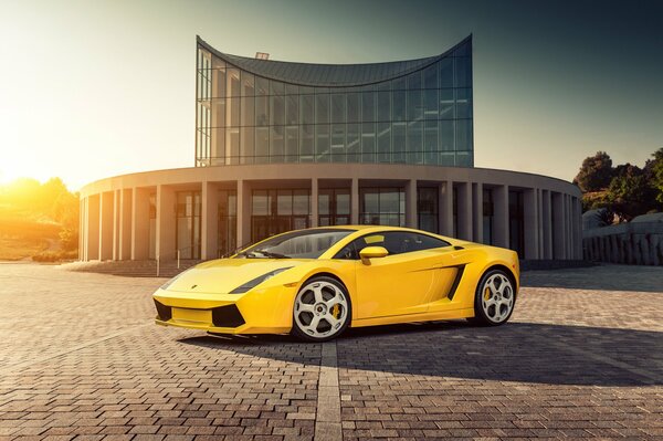 Yellow lamborghini gallardo on the background of a building in sunlight