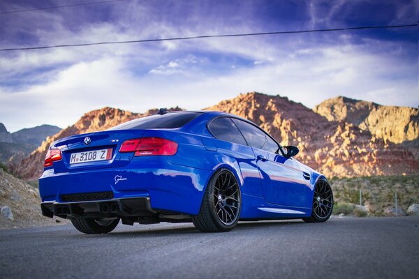 Blue car on the background of mountains and sky