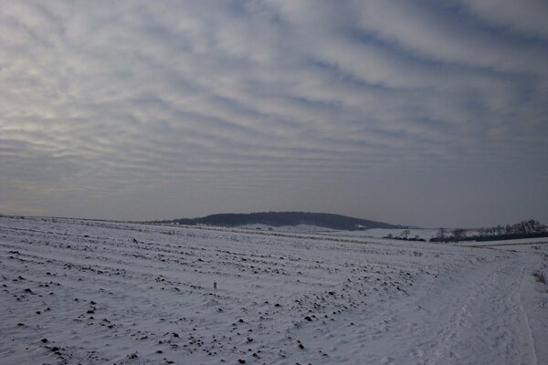 A snow-covered field against the background of mountains