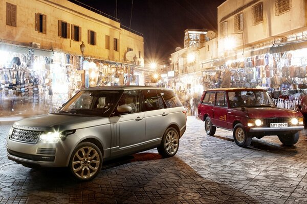 Coches Land Rover en medio de la ciudad nocturna