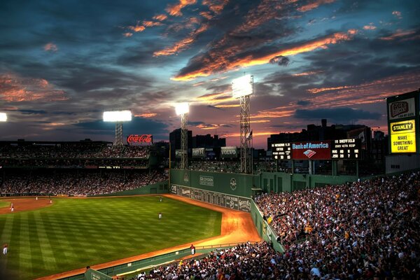 Evening photo of a baseball field with a full stadium