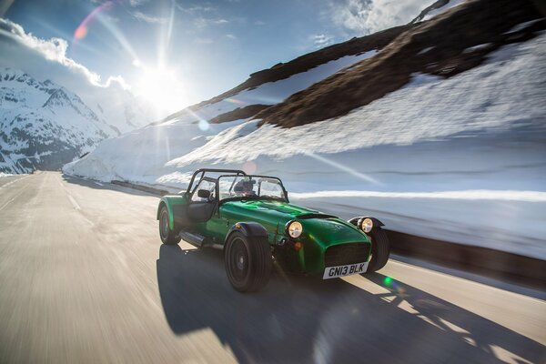 Auto retrò guida sulla strada sullo sfondo del paesaggio invernale