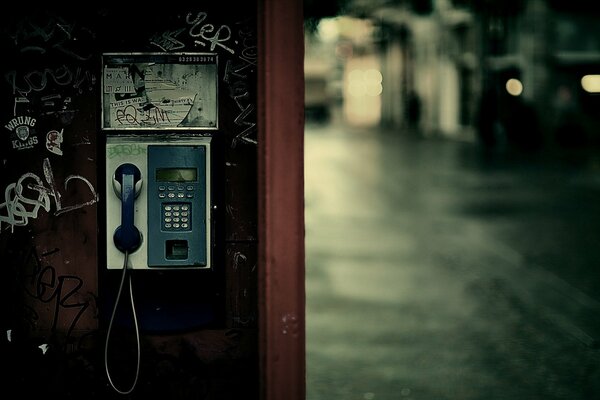 Budka telefoniczna wśród deszczowego miasta