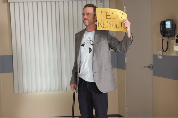 Dr. House hält ein Schild