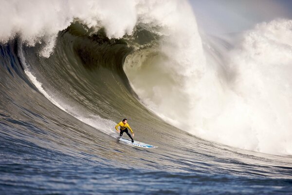 Surfista en una tabla en una gran ola de mar