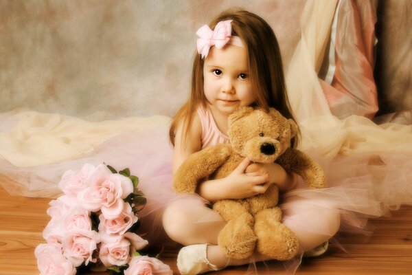 A little girl hugs a bear