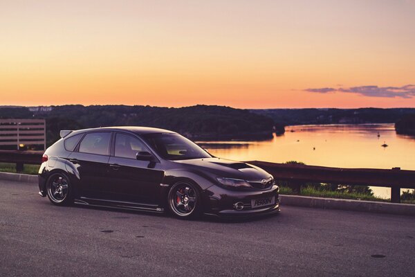 Subaru près de la rivière pendant le coucher du soleil