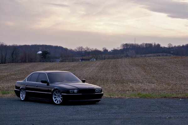 An old car standing in the background of a field